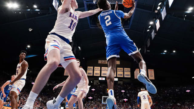 Feb 27, 2024; Lawrence, Kansas, USA; Brigham Young Cougars guard Jaxson Robinson (2) shoots as Kansas Jayhawks guard Johnny Furphy (10) defends during the second half at Allen Fieldhouse. Mandatory Credit: Denny Medley-USA TODAY Sports